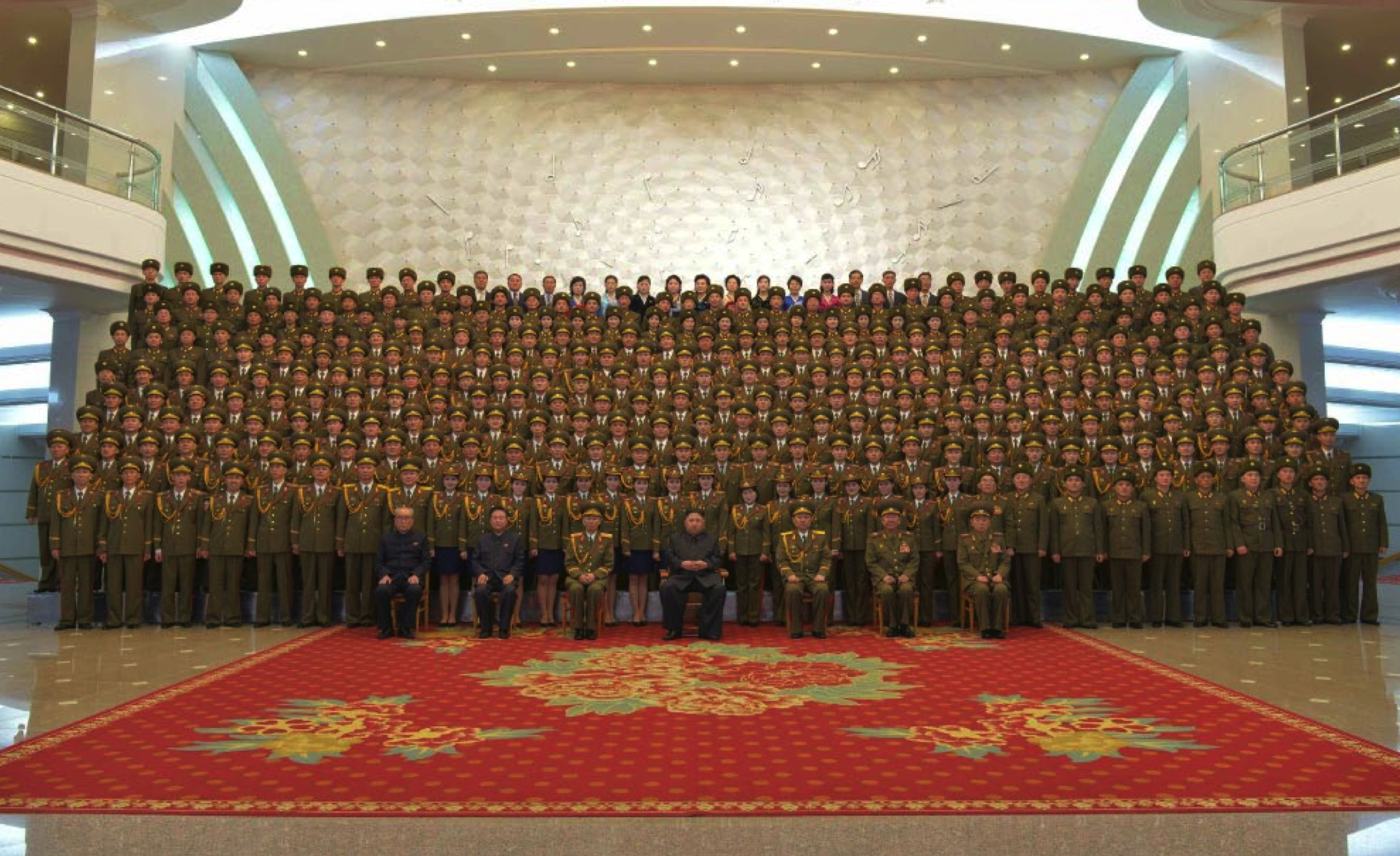 Kim Jong Un, senior DPRK officials and members of the State Merited Chorus (Merited State Choir) pose for commemorative photograph in the lobby of the People's Theater in Pyongyang on February 22, 2017 in a photo which appeared top-center of the front page of February 23, 2017 edition of the WPK daily organ Rodong Sinmun.